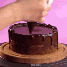 a person is decorating a chocolate cake with a piping bag