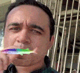 a man is holding a rainbow fish in his mouth .