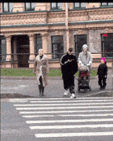 a group of people walking across a street with a sign that says ' exit '