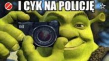 shrek is taking a picture with a camera and the words i cyk na policie are above him
