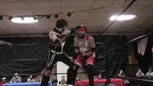 two wrestlers are fighting in a ring with an american flag on the wall