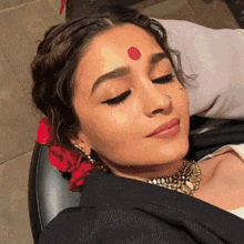 a woman with a red dot on her forehead and a nose ring