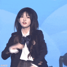 a girl wearing a beret and a school uniform looks at the camera