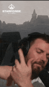 a man wearing headphones with a starforge logo on the bottom