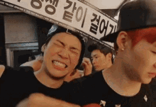 a man with red hair is making a funny face in front of a sign that says ' a ' on it .