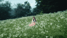 a woman sitting in a field of white flowers