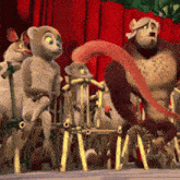 a group of monkeys are sitting on a fence with a red curtain behind them
