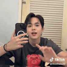 a young man taking a picture of himself in a mirror with a tiktok account
