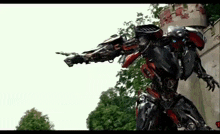 a robot is standing in front of a castle and pointing at something .