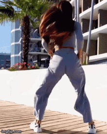 a woman is dancing in front of a building with imgflip.com at the bottom of the screen