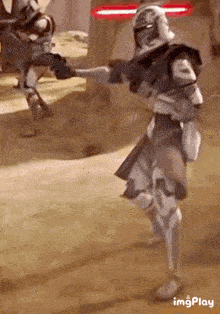a clone trooper is holding a gun in his hand while standing on one leg .