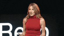 a woman in a red dress is standing in front of a large white letter b
