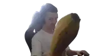 a man wearing headphones is holding a large banana in his hand