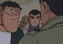 a group of men are standing next to each other and talking to each other .