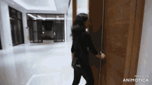 a woman opens a door with the words made in animatica on the bottom