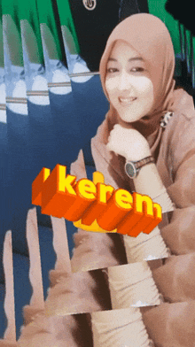 a woman wearing a hijab and a watch with the word keren behind her