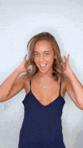 a woman wearing a blue tank top and a silver necklace