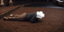 a man wearing a chef 's hat is laying on the ground in front of a white car