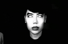 a black and white photo of a young man with white eyes .