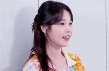 a close up of a woman 's face with a ponytail and earrings