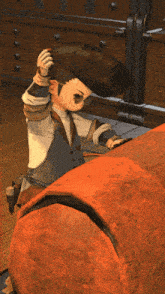 a cartoon character is sitting on a large orange item