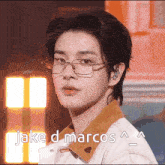 a close up of a person wearing glasses with the words " jake d marcos " below him