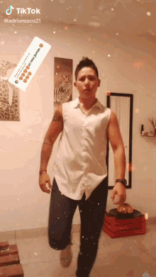 a man in a white shirt and black pants is dancing in front of a mirror and a sign that says " tiktok "