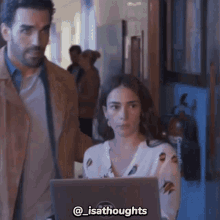 a man and a woman are standing next to each other with a laptop in front of them with the caption @isathoughts