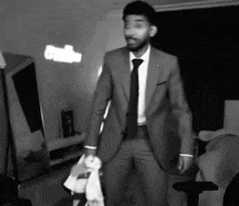 a man in a suit and tie is standing in a room with a sign that says radio