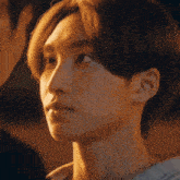 a close up of a young man 's face with a man 's head in the background .