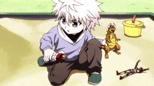 a little boy is playing with toys in a sandbox with a yellow bucket
