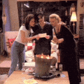 three women standing around a table looking at something