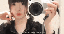 a woman is holding a camera in her hand and taking a picture of herself .