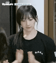 a girl wearing a black shirt that says r.o.ka on it