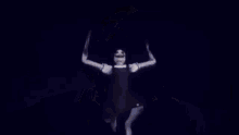 a scary doll with a big smile on her face is taking a selfie with her arms outstretched .