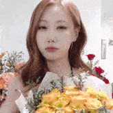 a woman holding a bouquet of yellow flowers