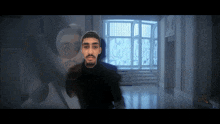 a man with a beard is standing in a hallway with a window