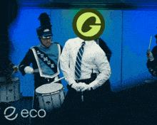 a man in a marching band playing drums with a green circle with the letter g on it