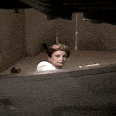 a woman in a white shirt is laying on a bed in a room