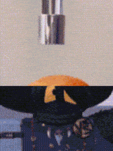 a close up of a cartoon character 's face with a yellow eye and a black hat .