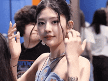 a woman wearing a blue dress and a necklace has a ring on her finger and a shirt that says roxy