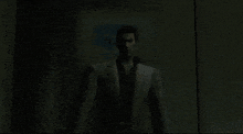 a man in a white suit and black shirt is standing in the dark