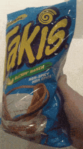a person is holding a bag of takis in a buckin ' ranch flavor