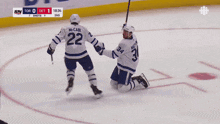a hockey player with the number 22 on his jersey holds hands with another player