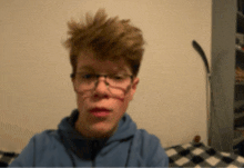 a boy wearing glasses and a blue hoodie