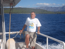 a man is sitting on a boat wearing a shirt that says ' srastva '