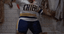 a man wearing a chiefs jersey is holding a hockey puck