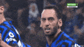 a man in a blue shirt with a g on it