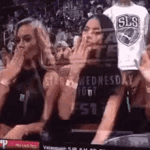 a group of people are sitting in a stadium watching a basketball game on wednesday .