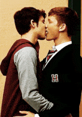 two young men are kissing with the letter h on their jackets